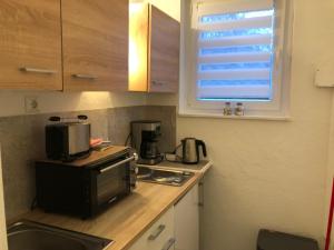 a small kitchen with a microwave and a stove at FEWO Priel Watt Nr.2 in Cuxhaven +6 photos