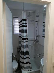 a bathroom with a black and white shower curtain at FEWO Priel Watt Nr.2 in Cuxhaven