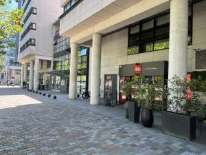 a building with pillars and plants in front of it at ibis Paris Bercy Village in Paris