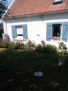 a dog sitting in the yard of a house at La Détente in Rinxent
