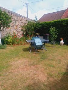 a picnic table and chairs in a yard at La Détente in Rinxent