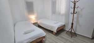 a white room with two beds and a lamp at בית בכפר in Kefar Pines