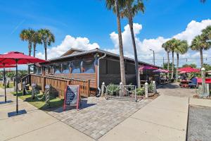 a restaurant with palm trees in front of a building at El Matador- Beachside Haven 210 in Fort Walton Beach