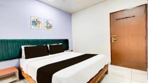 a bedroom with a large bed and a wooden door at Shree Hotel in Rewāri