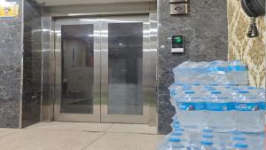 a stack of bottles of water in front of an elevator at Shree Hotel in Rewāri