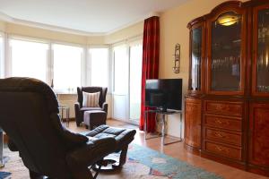 a living room with a chair and a television at Haus Trafalgar App 255 in Cuxhaven