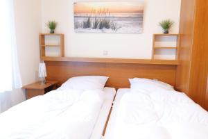 two beds in a bedroom with a head board at Haus Trafalgar App 255 in Cuxhaven +20 photos