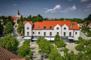 a large white building with an orange roof at PALOMA Průhonice in Prŭhonice
