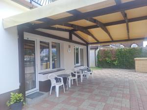 a patio with tables and chairs under awning at willa grazyna 2 in Dźwirzyno +14 photos