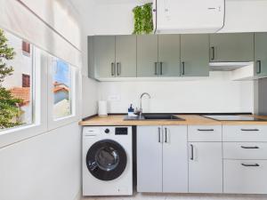 a kitchen with a washing machine and a sink at Apartments Jan in Banjole +70 photos