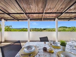 a table with glasses and plates on it on a patio at Apartments Jan in Banjole
