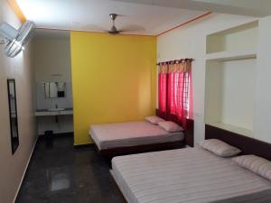 a room with two beds and a sink and a mirror at Pattiah Naidu Palace in Palni