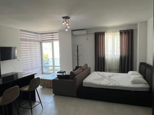 a bedroom with a bed and a couch and a desk at Apartments Kristi in Shëngjin