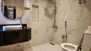 a bathroom with a toilet and a sink and a mirror at أجنادين للشقق المخدومة in Riyadh +35 photos