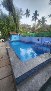 a blue swimming pool with a blue tile wall at Casa Viora in Calangute