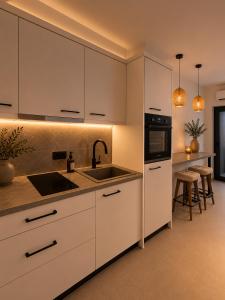 a kitchen with white cabinets and a sink at Salsedo Seaside Rooms 2 in Kanali
