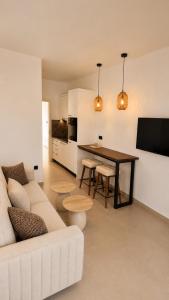 a living room with a white couch and a table at Salsedo Seaside Rooms 2 in Kanali