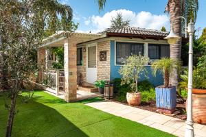 a small blue house with a green yard at אצל ירדנה- מתחם אירוח כפרי ענק למשפחות in Sifsufa +34 photos