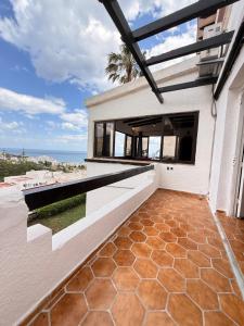 a house with a balcony with a view of the ocean at C2 Résidence CHATT in Tétouan