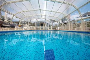 a large swimming pool with a roof over it at אצל ירדנה- מתחם אירוח כפרי ענק למשפחות in Sifsufa