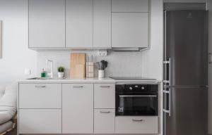 a kitchen with white cabinets and a black refrigerator at Perfect cosy living in Stockholm +4 photos