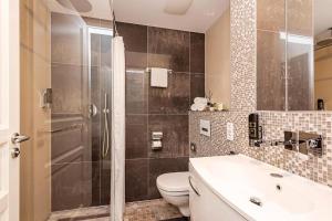 a bathroom with a shower and a toilet and a sink at Arabel Design Apartments in Berlin