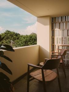 a balcony with a chair and a window at Anandaya Sanur in Sanur