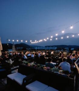 a crowd of people sitting on a balcony at night at Centrál apartmán in Zvolen