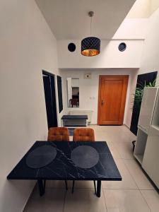 a dining room with a black table and chairs at Centrál apartmán in Zvolen
