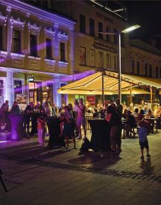 a group of people standing in a street at night at Centrál apartmán in Zvolen