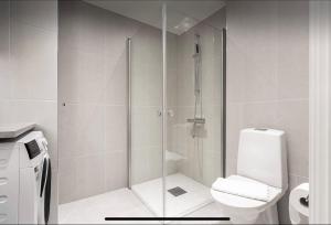 a bathroom with a glass shower with a toilet at Perfect cosy living in Stockholm