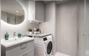 a bathroom with a washing machine and a sink at Perfect cosy living in Stockholm