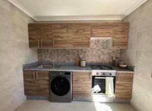 a kitchen with a stove and a dishwasher at Le Balcon Bohème des Golfs in Marrakesh +3 photos