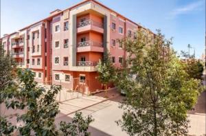 an apartment building with trees in front of it at Le Balcon Bohème des Golfs in Marrakesh