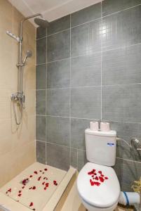 a bathroom with a toilet with red flowers on the floor at Le Balcon Bohème des Golfs in Marrakesh