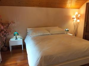 a bedroom with a large white bed and a table at Vivenda Por do Sol in Ponta do Sol