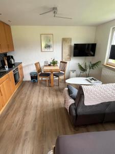 a kitchen and living room with a table and a couch at Ferienwohnung Zum Eifelelch in Daun