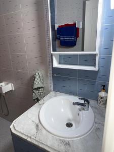 a bathroom with a white sink and a mirror at Beach apartment g in Sousse