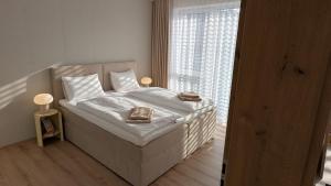 a bedroom with a bed with white sheets and a window at Apartment Nordic in Veselé