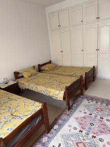 two twin beds in a room with a rug at Beach apartment g in Sousse