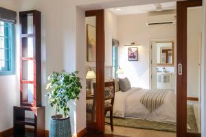 a bedroom with a bed and a mirror at Mammootty House Kochi - a VKation Experience in Cochin