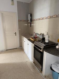 a kitchen with a stove and a white door at Beach apartment g in Sousse