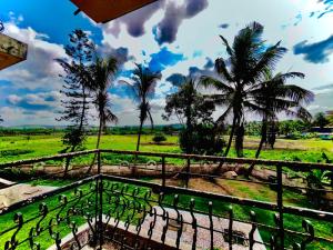 a view of a field with palm trees and a fence at Beachside Studio Apartment Baga in Baga