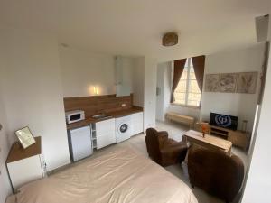 a bedroom with a bed and a desk and a microwave at Studio Château de Passy in Passy