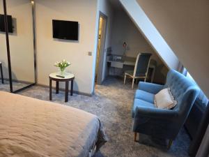 a bedroom with a bed and a chair and a desk at Hotel zur Kaiserpfalz in Kaiserpfalz