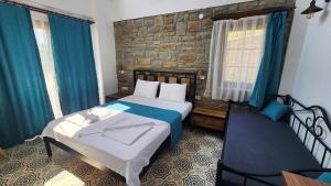 a bedroom with a bed and a chair in it at Bergüzar Hanım Konukevi in Gokceada Town