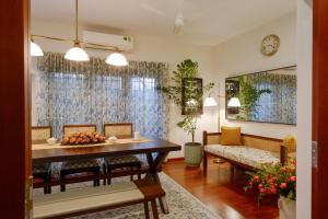 a living room with a table and a couch at Mammootty House Kochi - a VKation Experience in Cochin