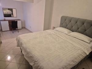 a bedroom with a large bed with a gray headboard at Apartman Pecara in Široki Brijeg +2 photos