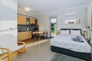 a bedroom with a large bed and a kitchen at Breathtaking view guesthouse in Psalidi