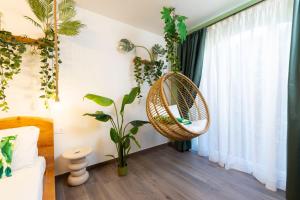 a room with a rattan hanging chair next to a window at Eteria Luxury Rooms Spa & Wellness in Posada +159 photos